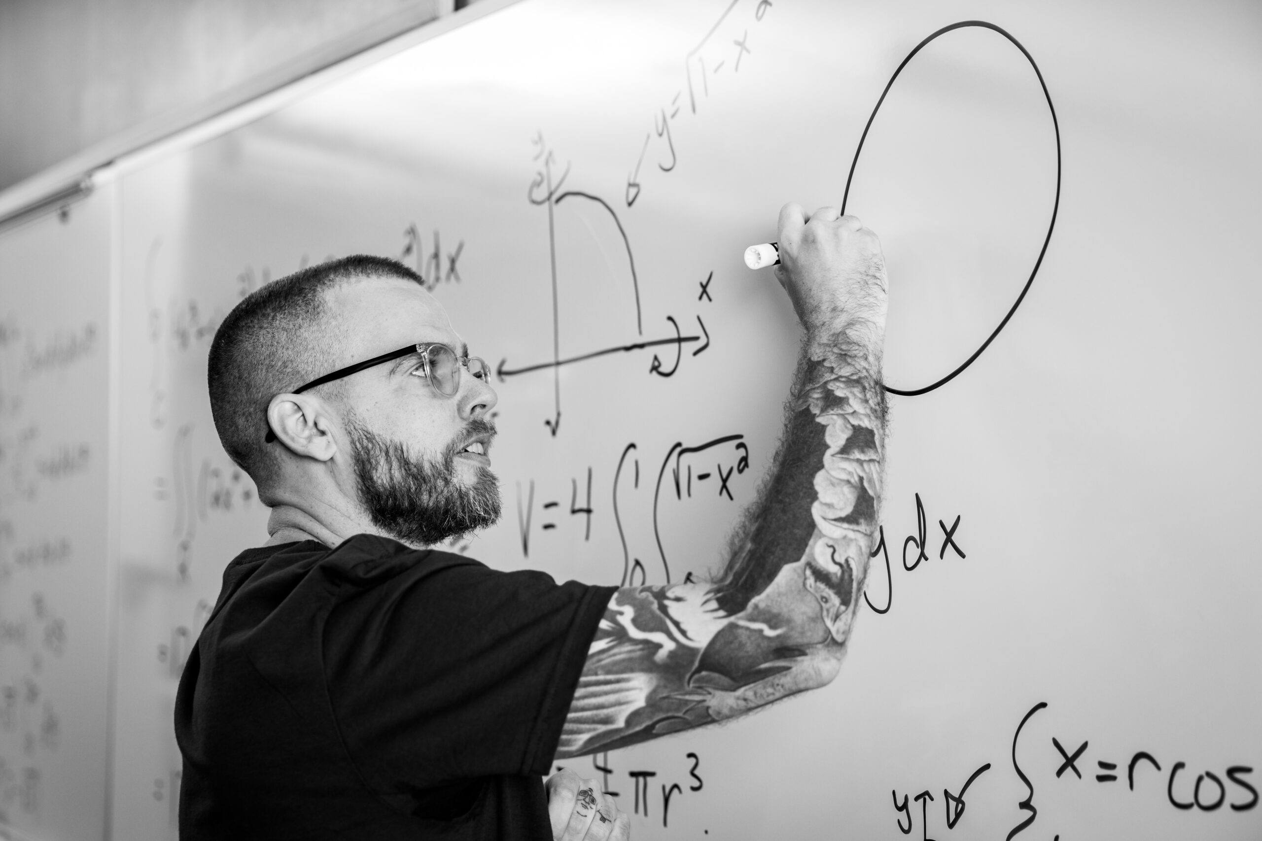TCC math faculty member Joshua Gregory covers a whiteboard with calculus formulas.